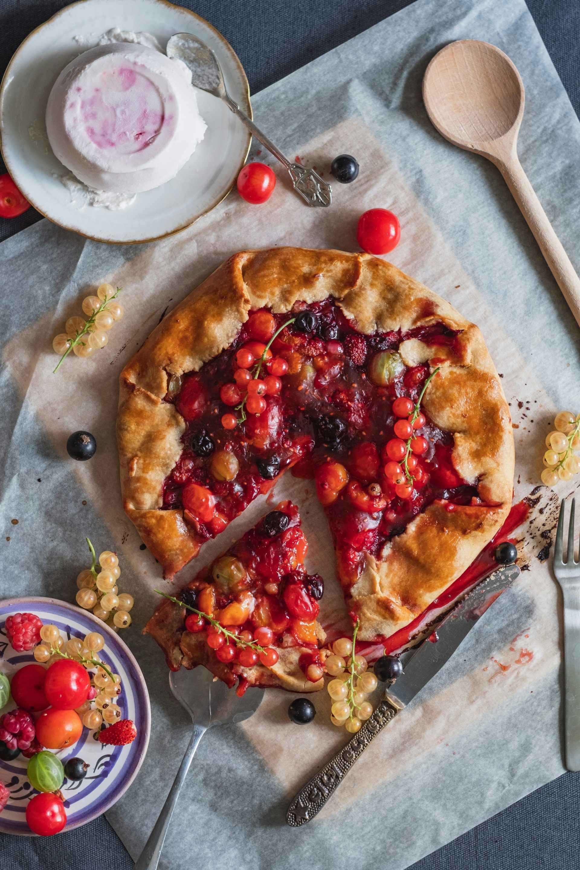 Köstliche, rustikale Beeren-Galette mit Johannisbeeren und Himbeeren auf Backpapier.