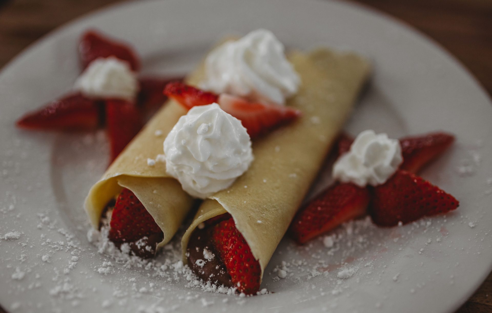 Frisch zubereitete Erdbeer-Crêpes mit Schlagsahne – perfekt für ein köstliches Frühstück oder Dessert.