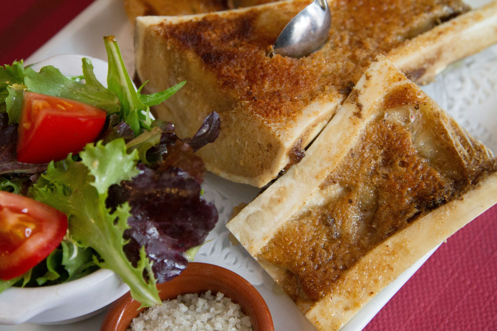 Ein weißer Teller mit geröstetem Brot und einem Salat